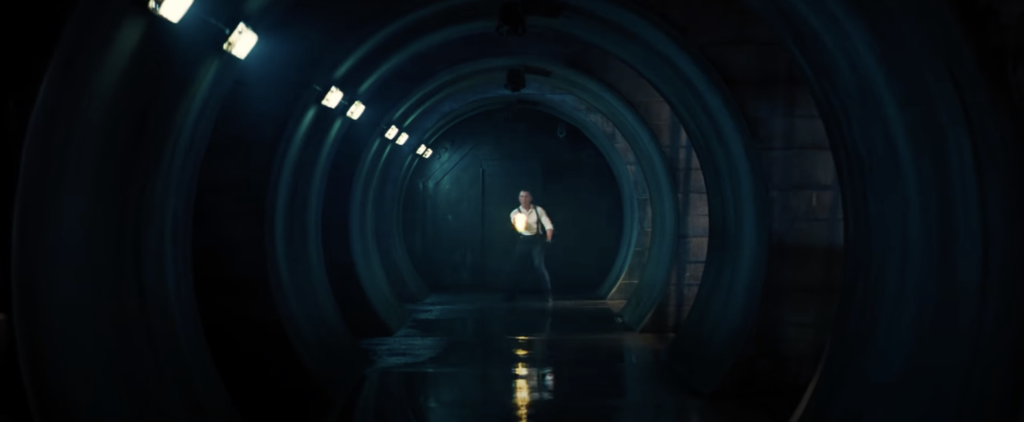 Shot from Skyfall of Bond in a tunnel shooting at the camera, visually resembling the classic gun barrel logo.