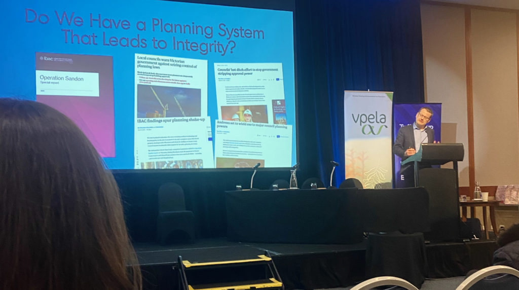 Image of me presenting at the 2023 VPELA conference in front of a slide reading "Do we have  a planning system that leads to integrity."
